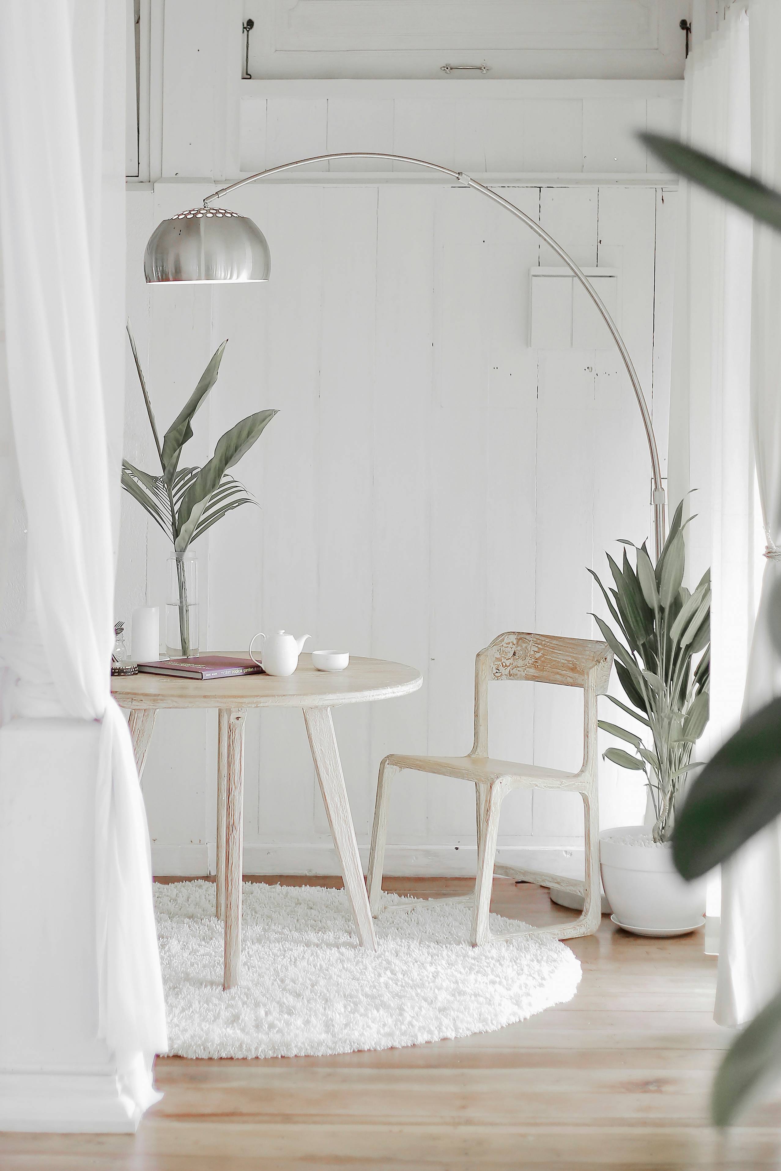 white steel chair in front round table on white rug