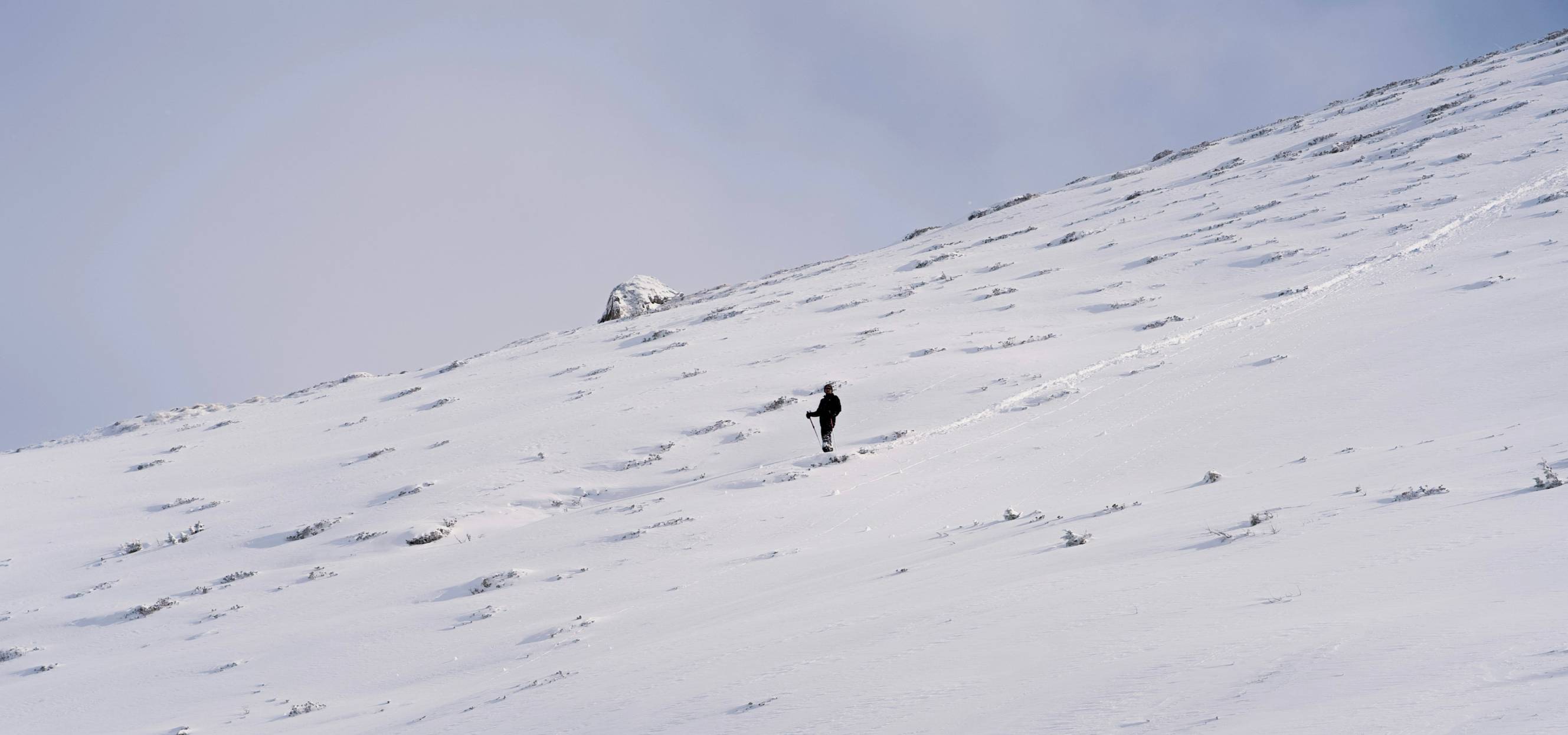 a person walking up the side of a snow covered mountain