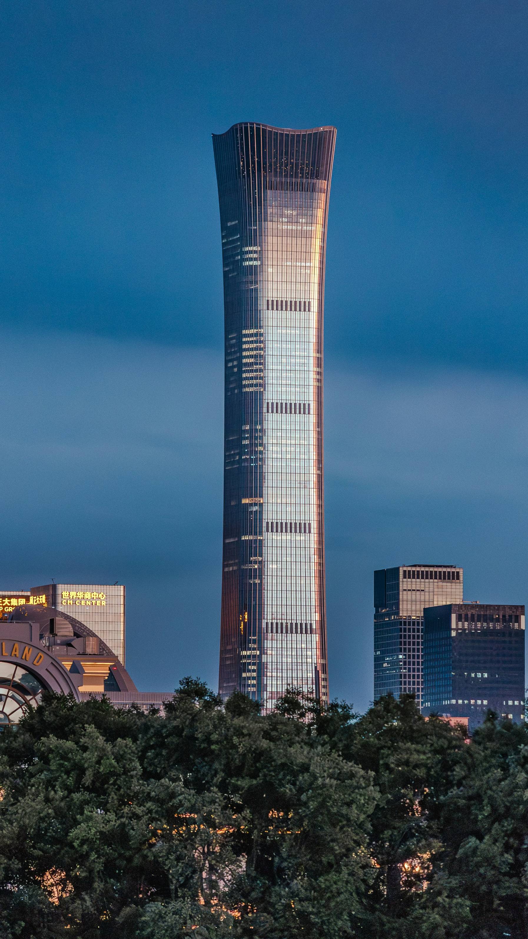 a tall building towering over a city at night