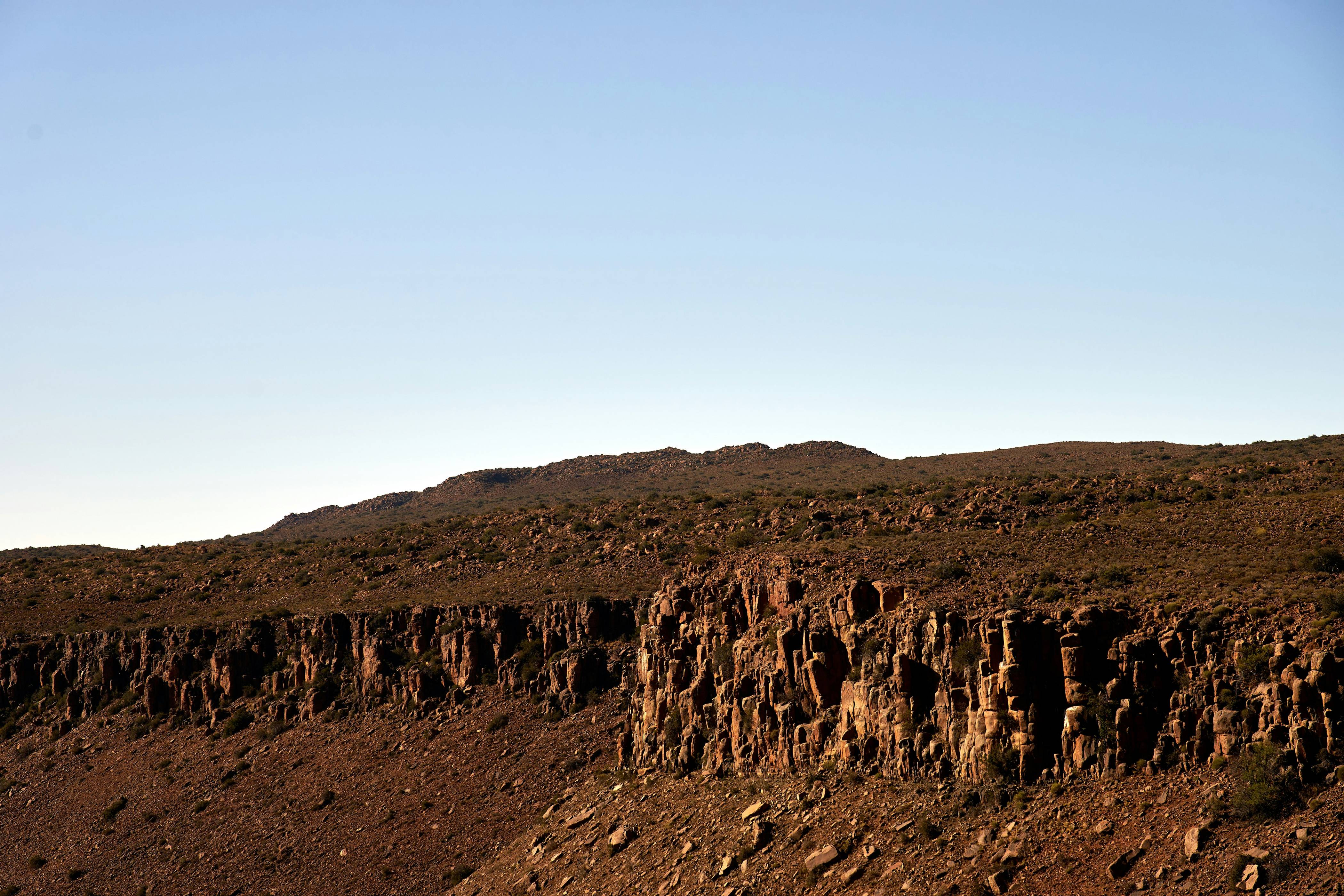 a rocky hill with a blue sky